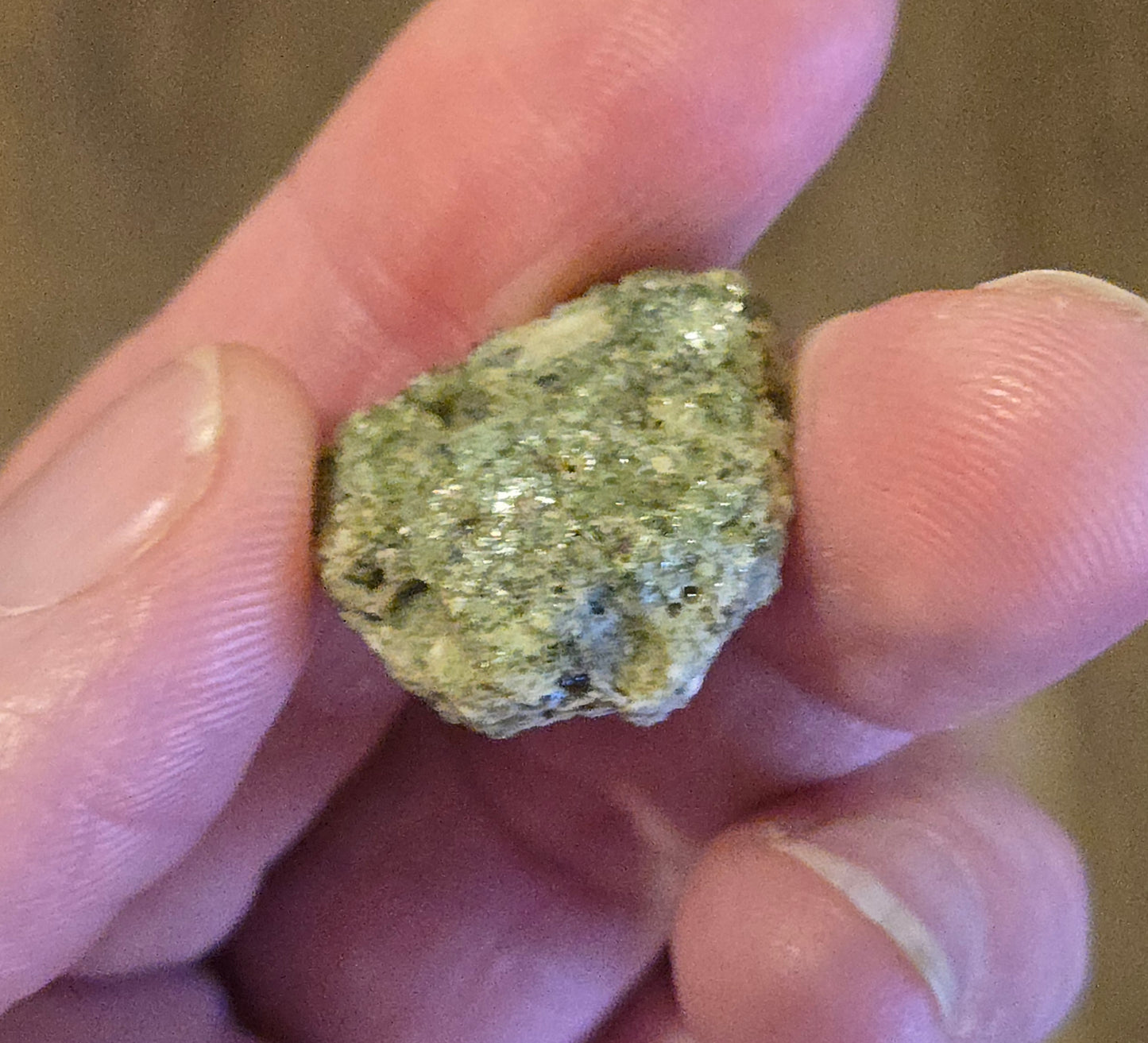 trinitite specimen from the 1945 Trinity nuclear test, White Sands New Mexico – 2.6g. Hand holding a small rock with a textured surface. 